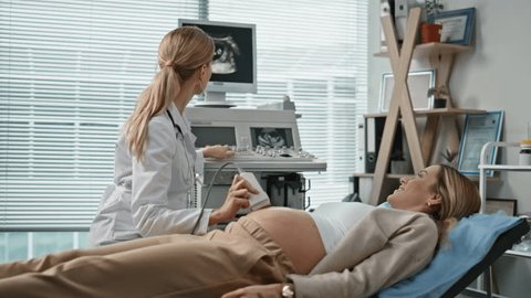 Gynecologist performing abdominal ultrasound scan on female patient to assess causes of irregular menstrual cycles.