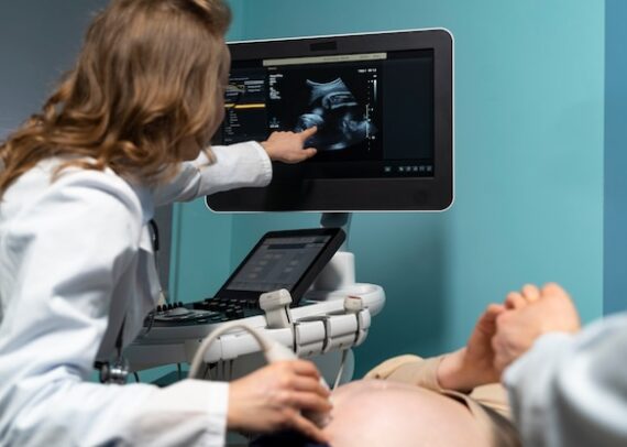 Gynecologist performing abdominal ultrasound scan on a female patient during a routine health checkup.