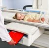 Medical X-ray machine scanning a patient with protective measures in a diagnostic center